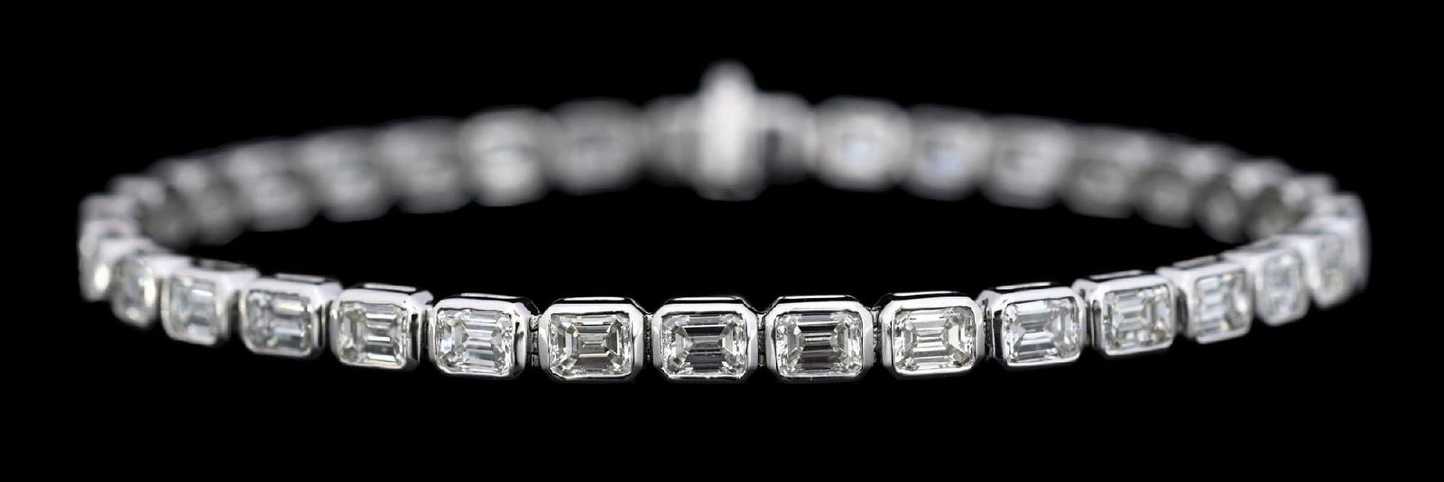 PLATINUM EMERALD CUT DIAMOND BRACELET: Ladies' platinum bezel-set diamond line bracelet consisting of 35 emerald cut natural diamonds with a total weight of 7.28cts, graded G/H, VS. Gross weight is 15.0 grams. Length measures 7". Width mea