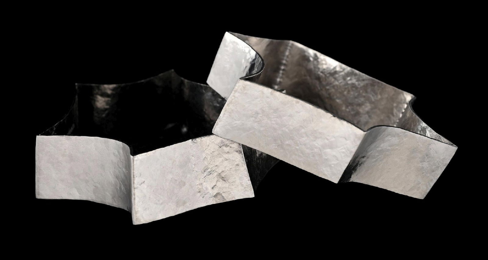 FRANK GEHRY FOR TIFFANY & CO, PAIR OF TORQUE BRACELETS IN TITANIUM: Matched pair (2) of Frank Gehry for Tiffany & Co., "Torque" bangle bracelets in titanium. Inside diameter measures approximately 2-1/2". Width measures 7/8". Both are marked "Tiffany & Co. (c) Gehry T