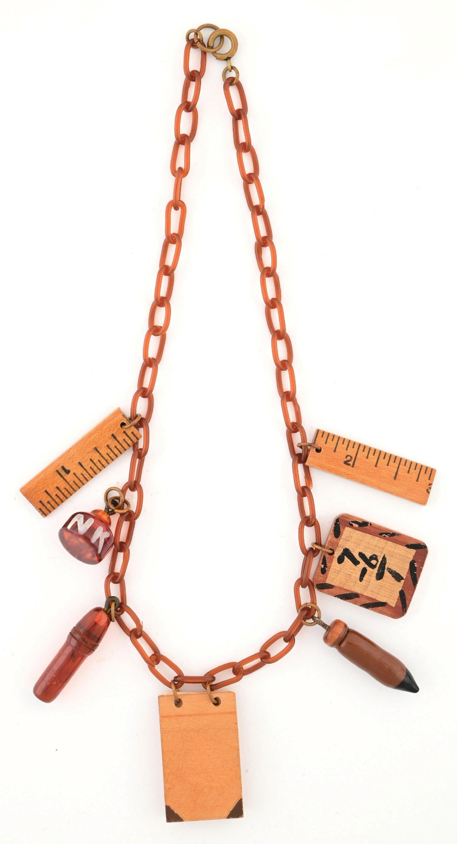 BAKELITE TEACHER-THEMED NECKLACE: Necklace features a celluloid chain with seven dangling charms attached by metal links along with a metal clasp enclosure. There are five wooden charms, two rulers, a chalk board, a notebook with actu