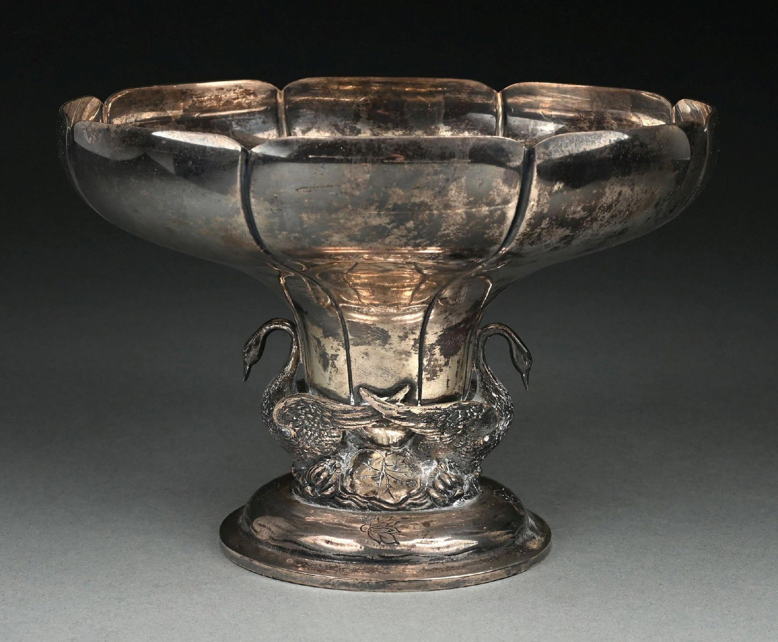 A STERLING CENTERPIECE BOWL: Hodgson Kennard & Co, Boston, the ribbed center tapering to a terrain base with lily pads and two cast and chased swan supports, and on a domed foot. Diameter: 9". Weight: 34.2 ozt. Condition: Dimensi