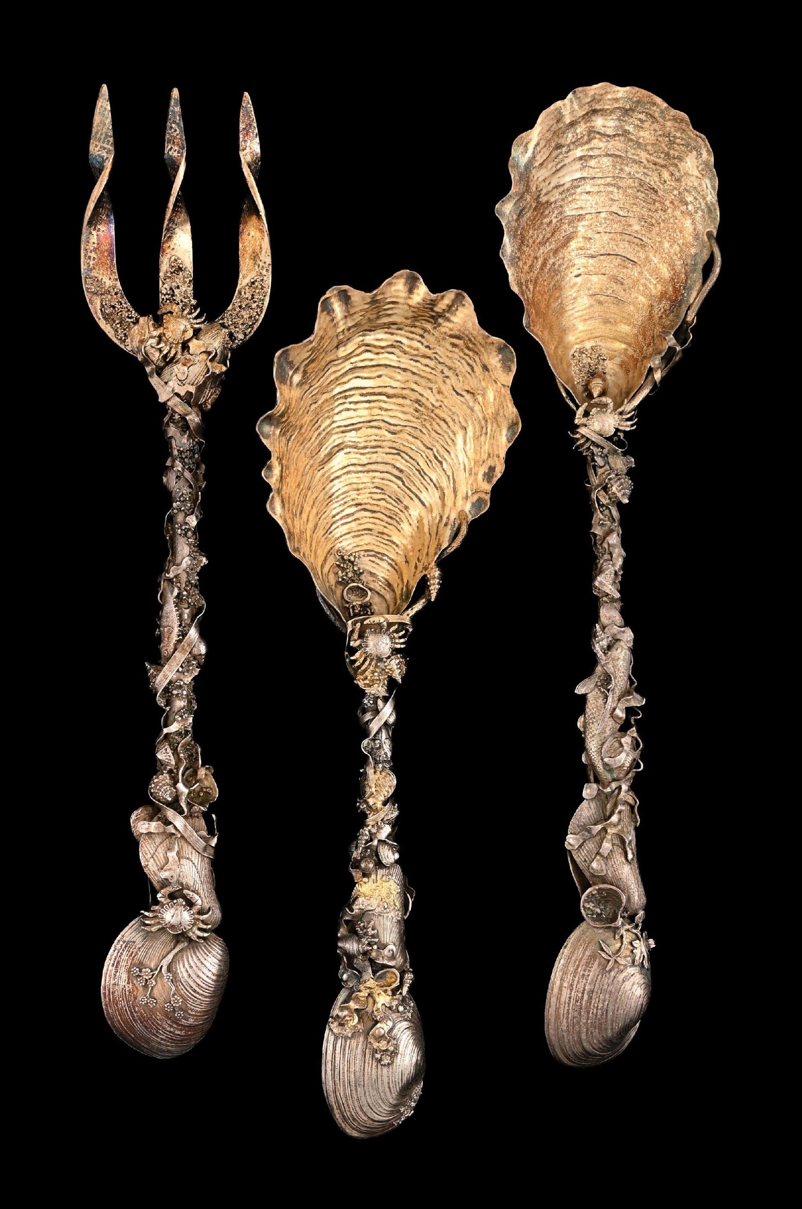 A PAIR OF GORHAM STERLING NARRAGANSETT PATTERN SALAD SERVERS: And another Spoon, each with seaweed around various shells and crabs, the spoons with oyster shell bowls (gilt); the other spoon shorter and with a broader bowl, the stem with partial gilding. Length 