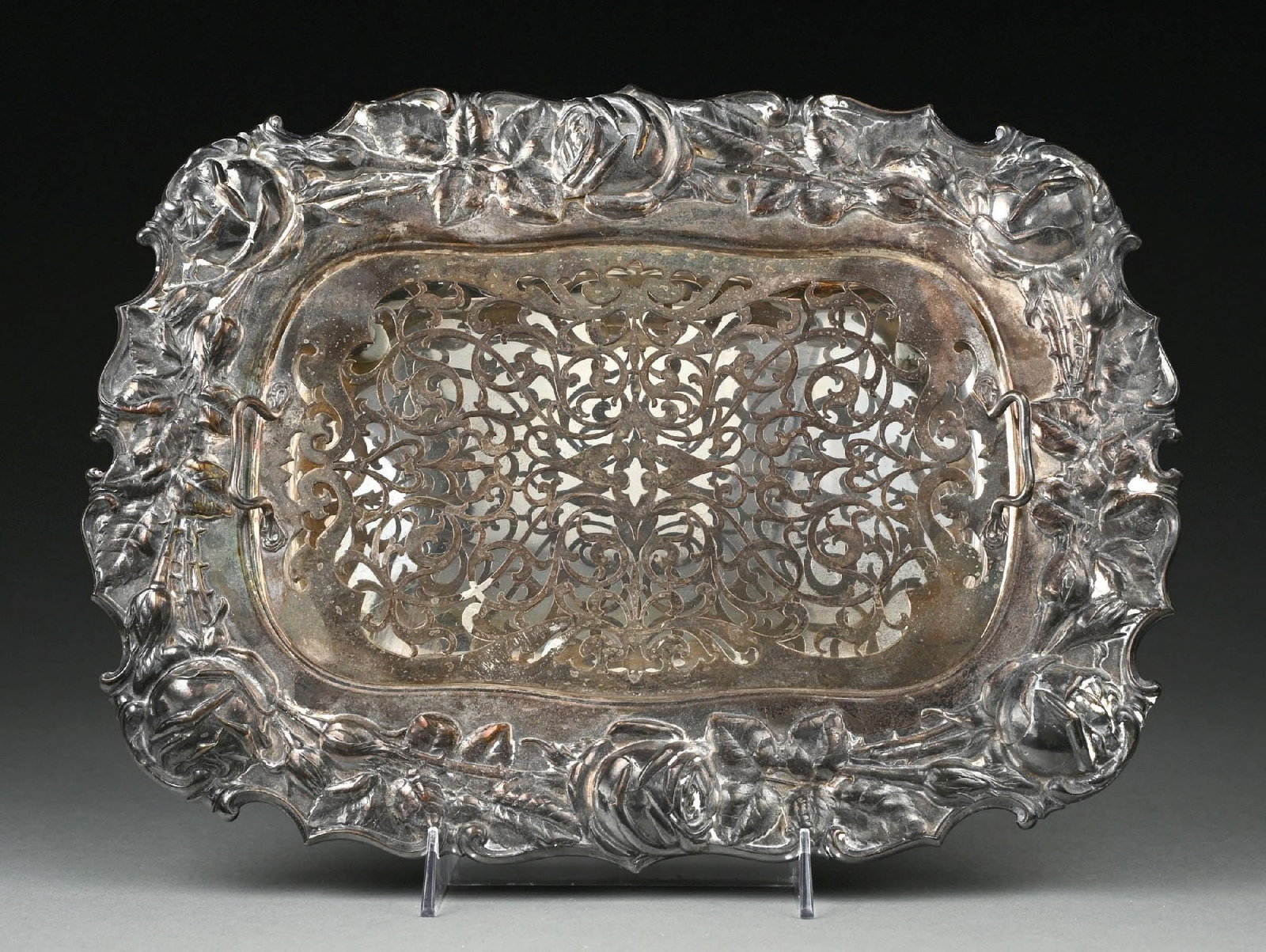 A WHITING STERLING ASPARAGUS DISH WITH STRAINER: 19th century. Oblong, the border chased with rose sprays in a shaped edge, the strainer pierced with scrolling foliage. Length: 15". Weight: 49 ozt. Condition: Dimensions: