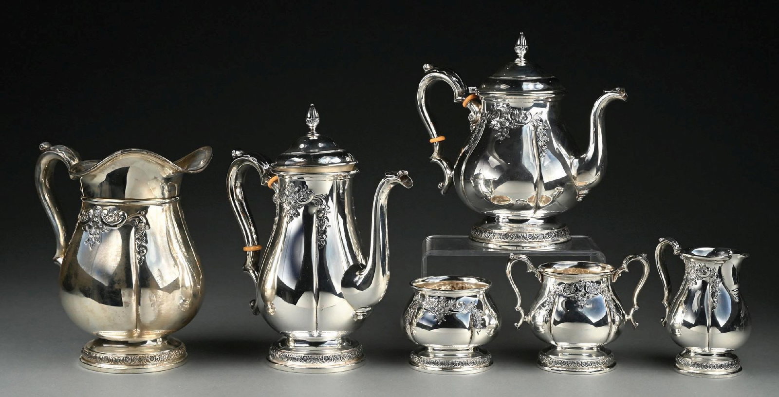 COLLECTION OF 6: INTERNATIONAL "PRELUDE" HAND-CHASED STERLING SILVER TEA SET AND WATER PITCHER: Very small dent to water pitcher. Gross weight: 99.5 ozt Condition: (Very Good - Excellent). Dimensions: