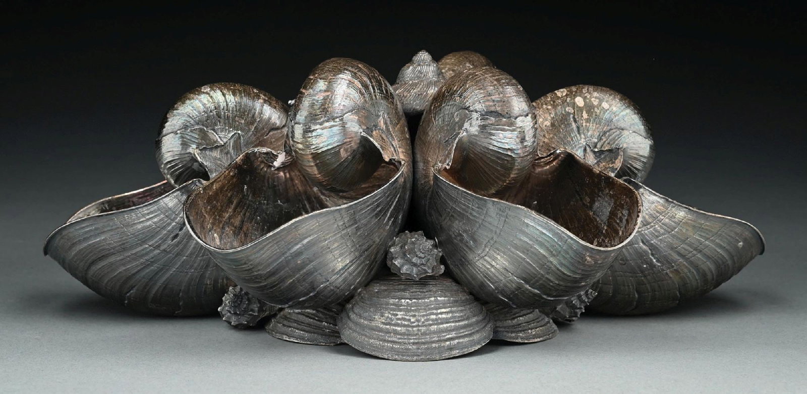 A BUCCELLATI STERLING FIGURAL CENTERPIECE: In the form of six joined nautilus shells on a shell base. Length: 14". Weight: 80 ozt. Condition: Dimensions: