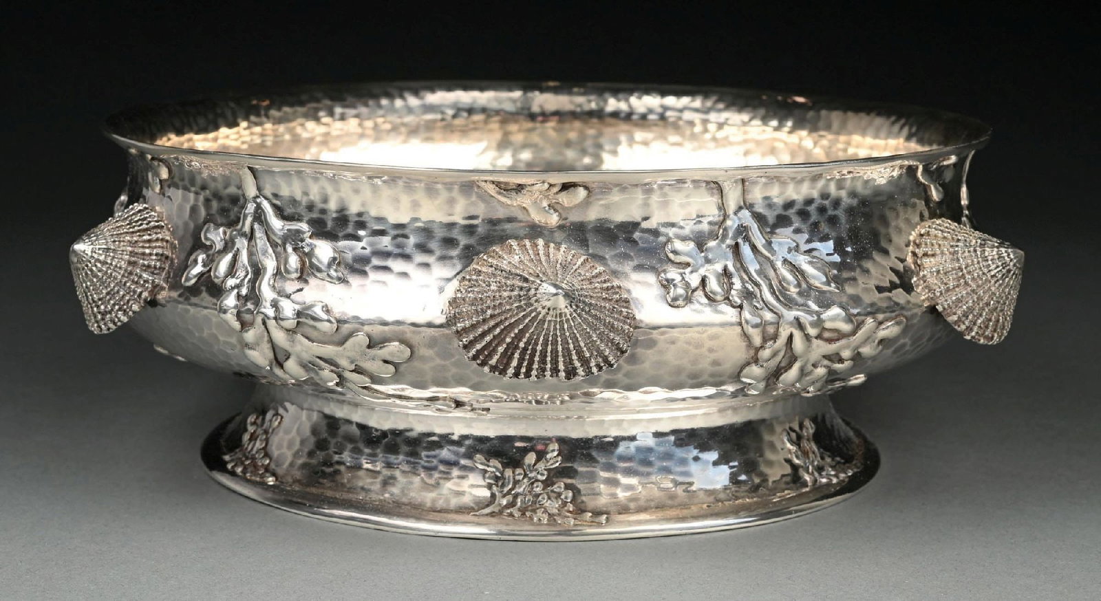 A TIFFANY STERLING MARINE-THEME CENTER BOWL: 19th century. Circular, the low sides with hammer finish and applied with cast and chased shells and seaweed at intervals. Diameter: 10-3/8". Weight: 46.8 ozt. Condition: Dimensions: