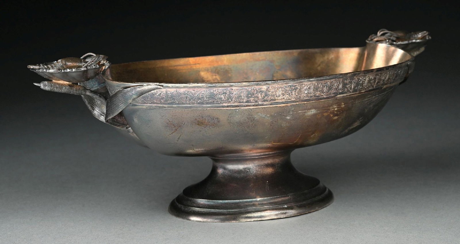 AN AMERICAN STERLING CENTER BOWL: Starr & Marcus, New York, oval with a chased rim, the handles cast with lobsters in shells. Length: 13". Weight: 25.7 ozt. Condition: Dimensions: