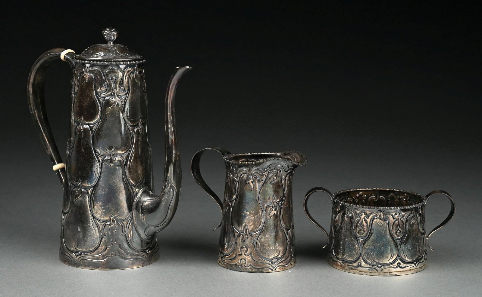 A GORHAM STERLING DEMITASSE COFFEE SET: 1901, including a coffee pot, cream jug and sugar bowl with tapering bodies chased with large pears. The underside of the cream jug marked 3690 in oval. Total weight: 19.5 ozt. Condition: Dimensions: