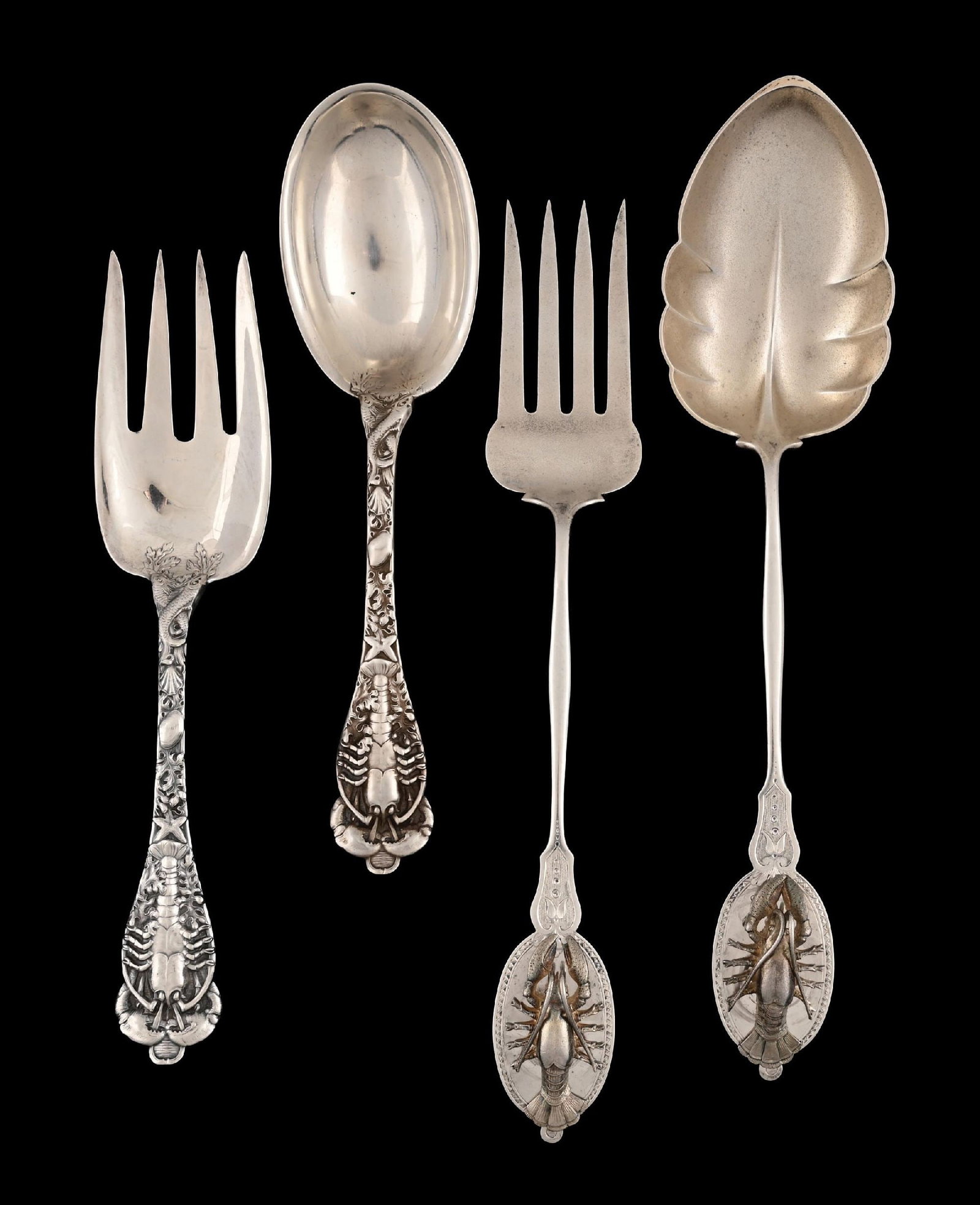 TWO PAIRS OF AMERICAN STERLING SALAD SERVERS: The first Watson, the stems chased with seaweed and shells, the handles with lobsters; the second, marked only J. E Caldwell, with narrow stems and broad handles applied with cast and chased lobsters.