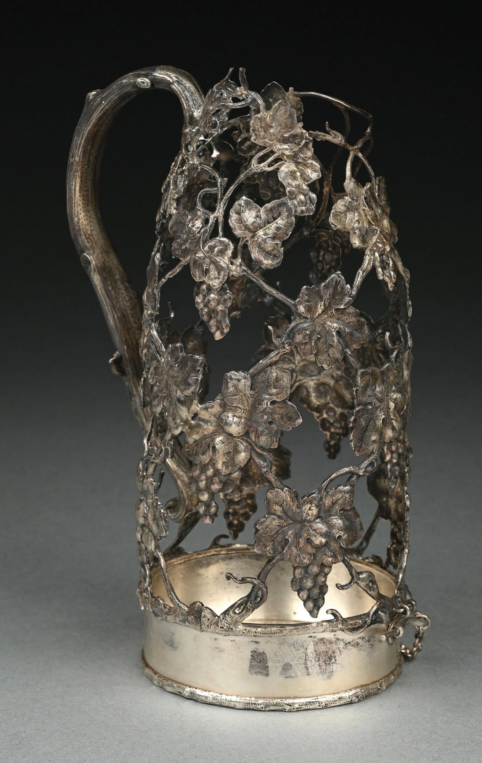 A GORHAM STERLING WINE BOTTLE CAGE: Formed as a trellis of grape vines with a branch handle above a hinged base. Height: 9-7/8". Weight: 16 ozt . Condition: Dimensions: