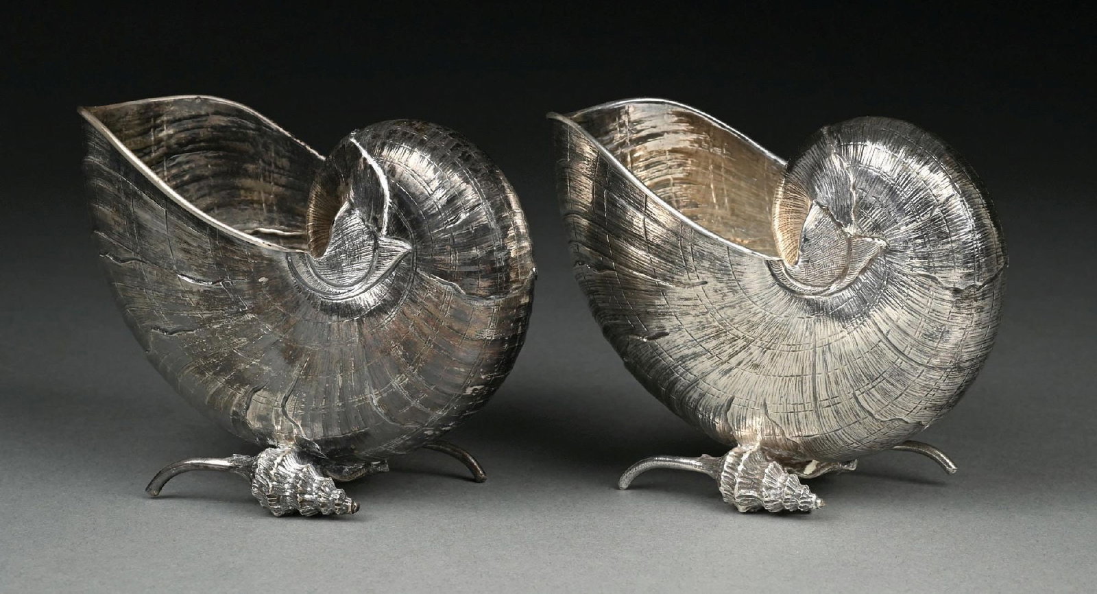 A PAIR OF BUCCELLATI STERLING SHELL FORM SPOON WARMERS: Each chased as a nautilus shell and on cast conch shell feet. Height: 4-3/8". Total weight: 20 ozt. Condition: Dimensions: