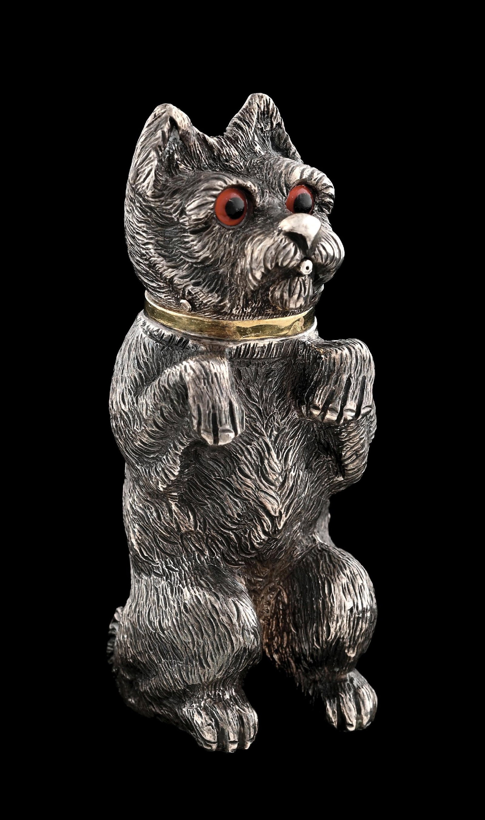 AN ENGLISH SILVER SCENT BOTTLE: London 1879, Leuchars & son, cast and chased in the form of a Scottie standing on its hind legs, the lid with a gilt dauber. Height: 2-5/8". Weight: 2.69 ozt. Condition: Dimensions: