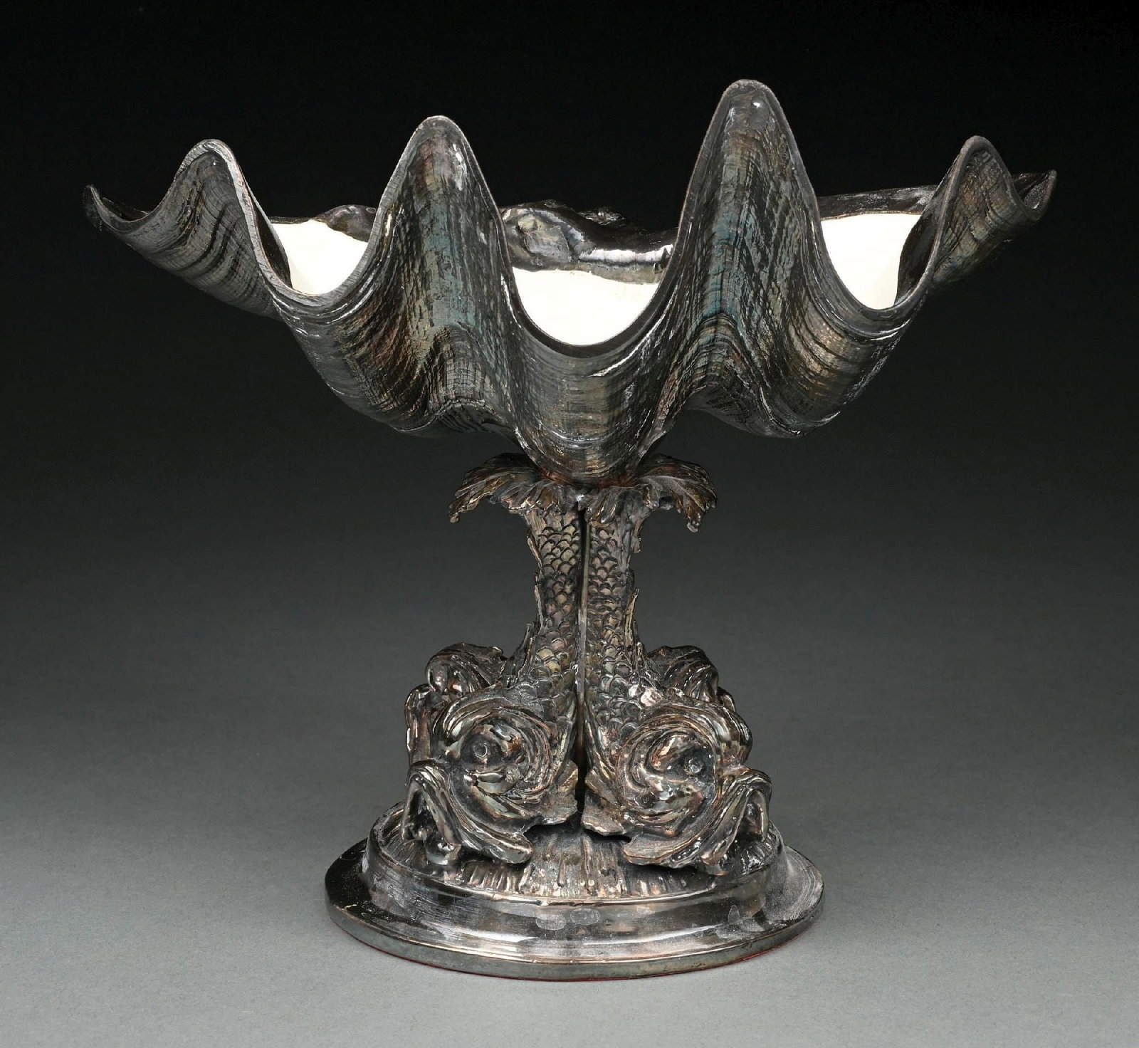 A LARGE SILVERED CLAM SHELL COMPOTE: Supported on four sea monsters, apparently unmarked. Height: 10-1/4". Condition: Dimensions: