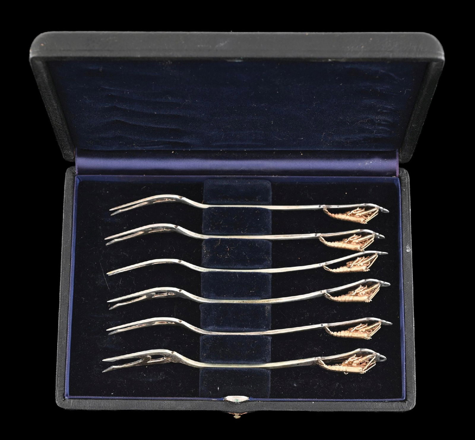 A SET OF SIX AMERICAN STERLING COCKTAIL FORKS: Webster, each with a tine stem, the handle set with a cast gilt lobster. In a black Morocco leather case. Length: 5-3/8". Total weight.: 3.3 ozt. Condition: Dimensions: