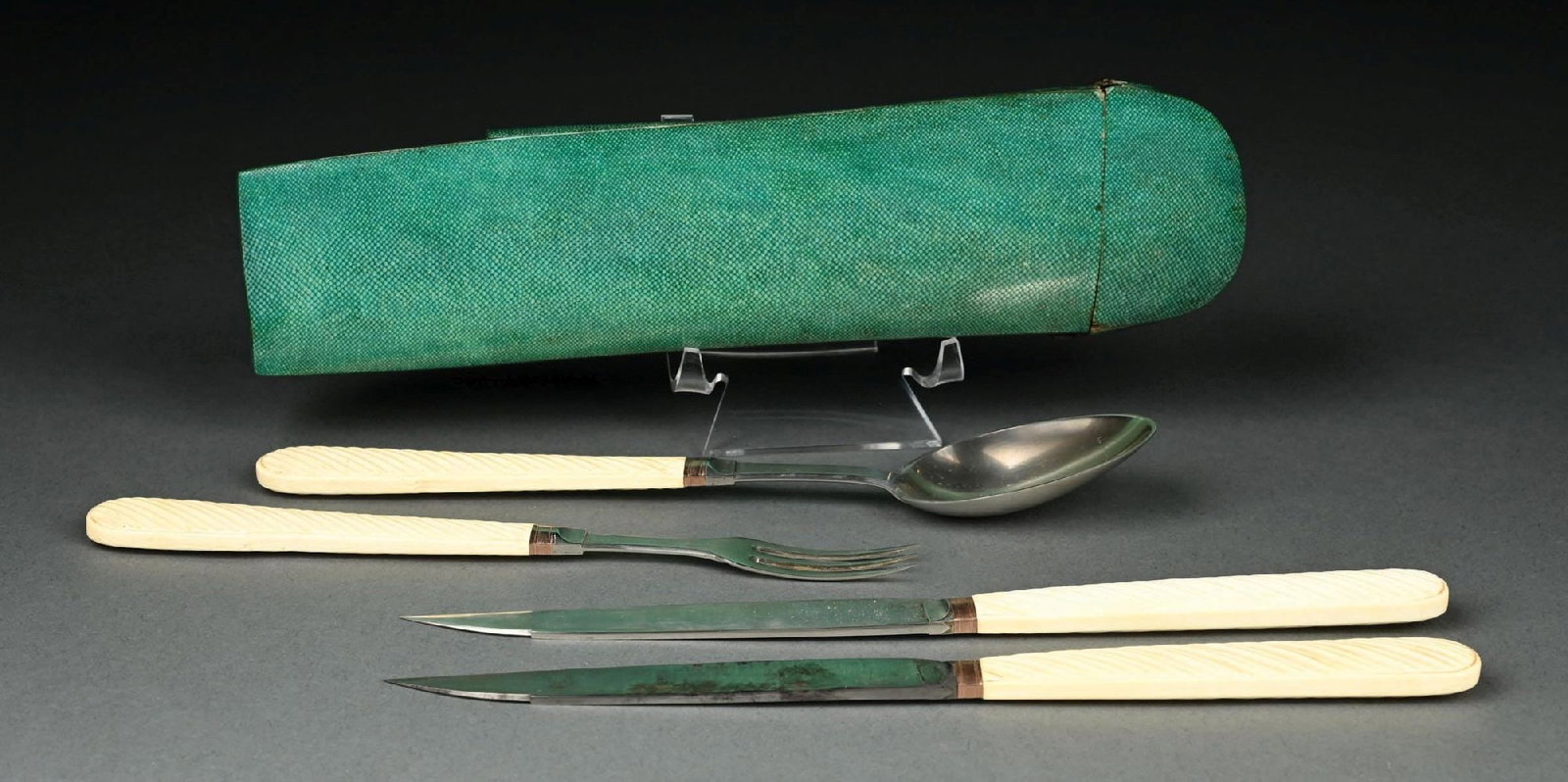 A CONTINENTAL SILVER TRAVELLING SET IN A SHAGREEN CASE: Comprising a spoon, a fork, a knife with a silver blade and another with a steel blade, unmarked. Length of case: 9-3/8". Condition: Dimensions: