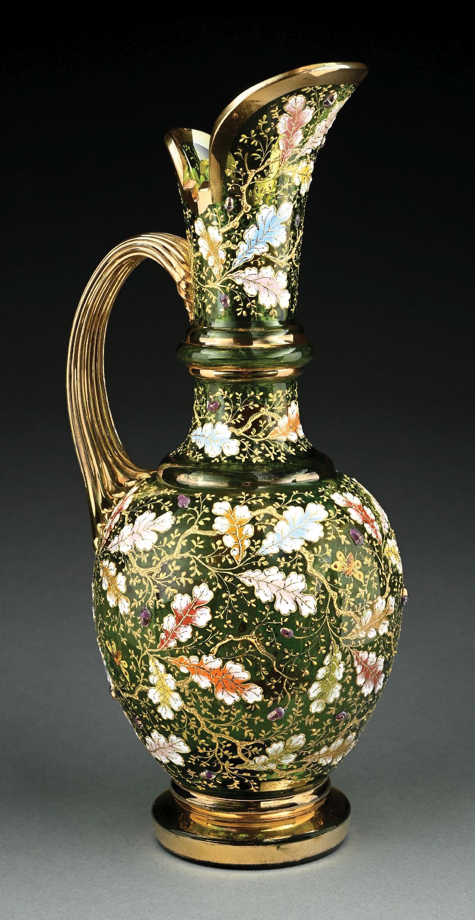 MOSER GREEN GLASS & ENAMEL PITCHER: A beautiful and elaborate glass and enamel pitcher by Moser. The 14-1/2" tall pitcher is composed of green glass with beautiful enameled acorns and flowers throughout. Further decorated with bees and 