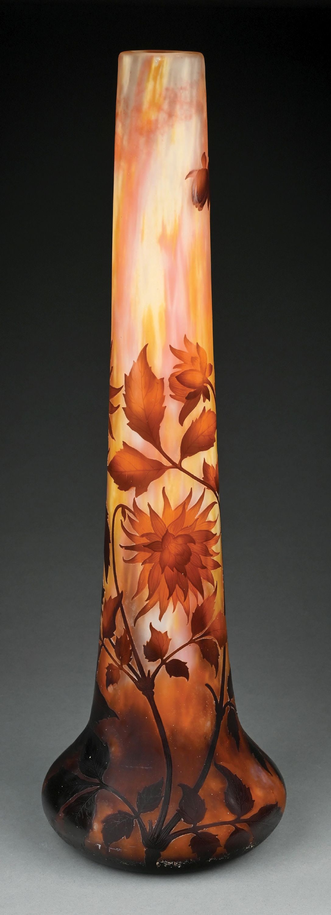 MONUMENTAL DAUM CAMEO FLORAL VASE: A beautiful and monumental cameo-cut vase by Daum. The 31-1/4" tall vase has a round bottom and tapering neck. The vase has a frosted and mottled background in shades of oranges, yellows, creams, and 