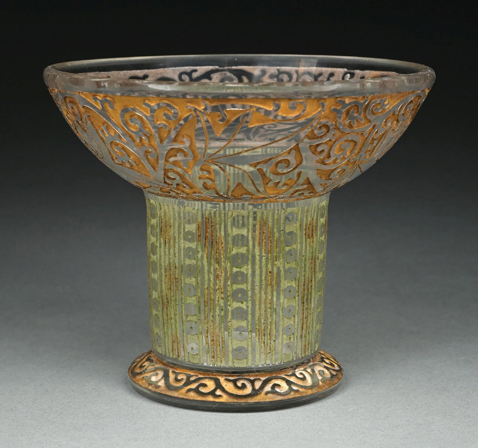 DAUM ACID CUT BACK TWO STAIN COMPOTE: A beautiful acid cut compote by Daum. The 6-1/4" compote has a diameter of 7-1/2". It has a clear background and deeply acid cut pattern throughout. The mouth and foot have a gold stain, while the bod