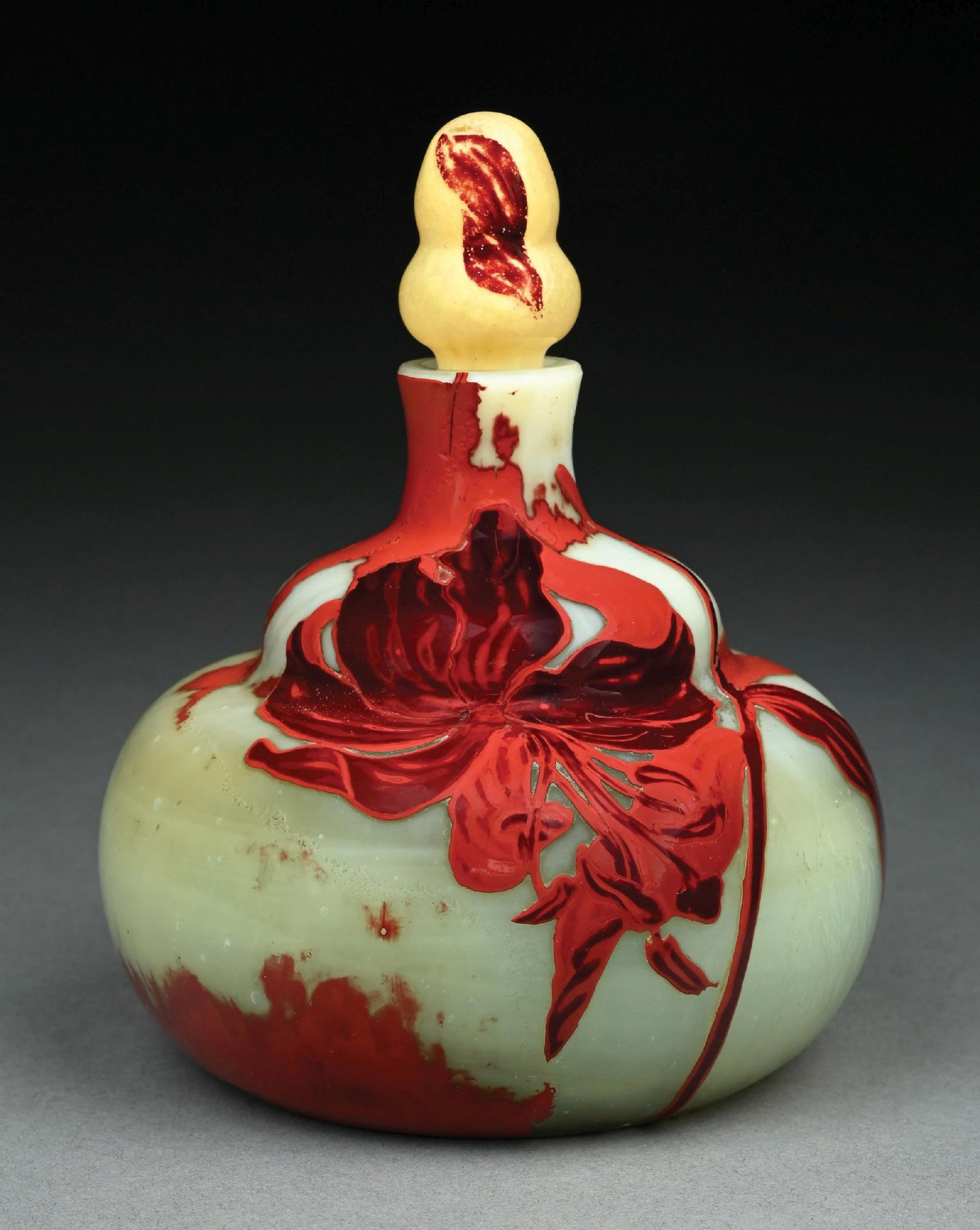 GALLE CAMEO BOTTLE W/ STOPPER: A beautiful cameo-cut glass bottle with stopper by Galle. The bottle stands 7" tall to the top of the stopper, and has a round bottom form. The bottle has a frosted cream-colored background with beaut