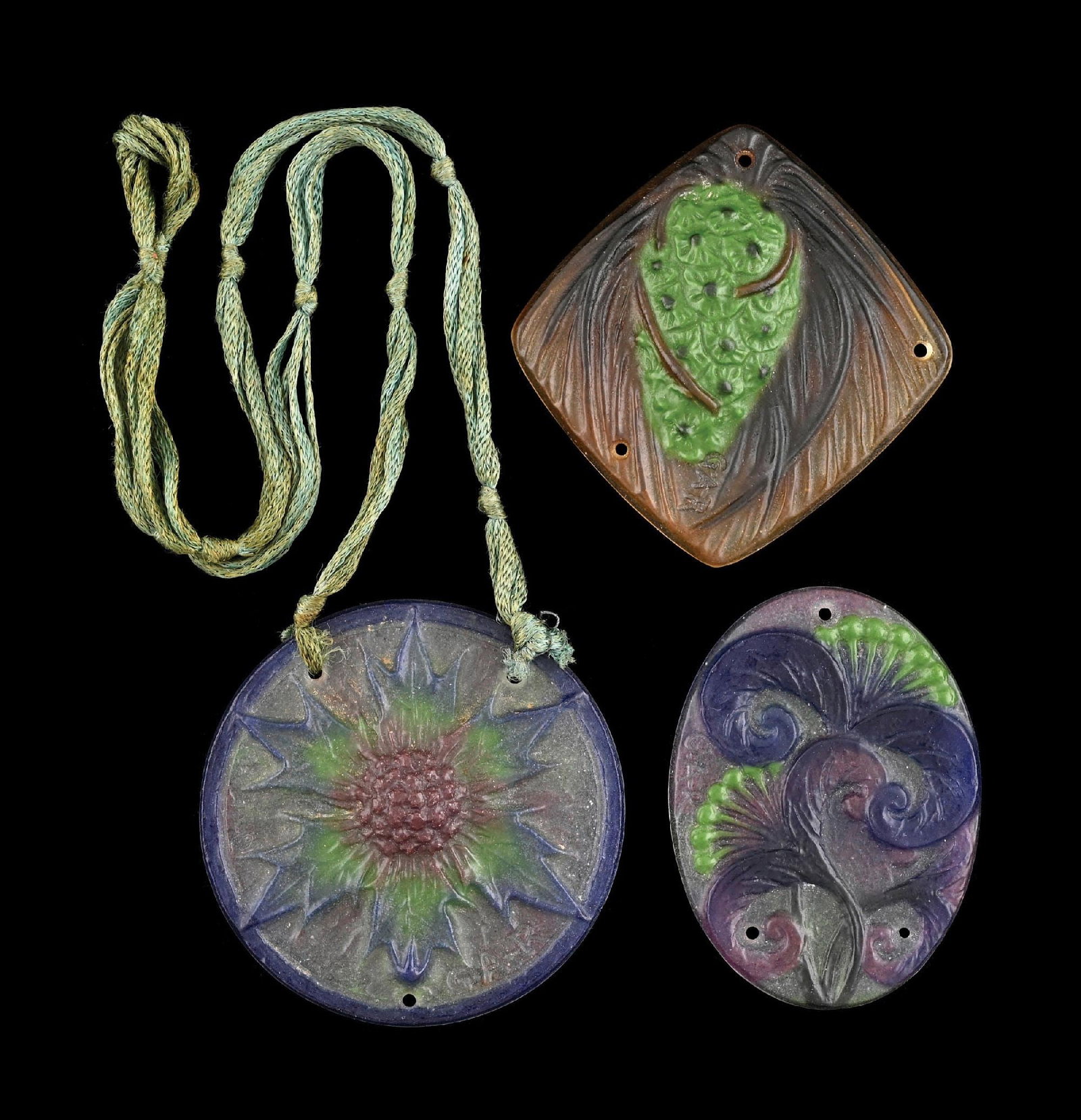 COLLECTION OF 3: PATE DE VERRE PENDANTS BY G. ARGY ROUSSEAU: A lovely set of three Pate de Verre pendants by G. Argy Rousseau. (A) A diamond-shaped pendant with green pine cone. Signed "GAR". (B) An oval-shaped pendant with a frosted purple background and Pate