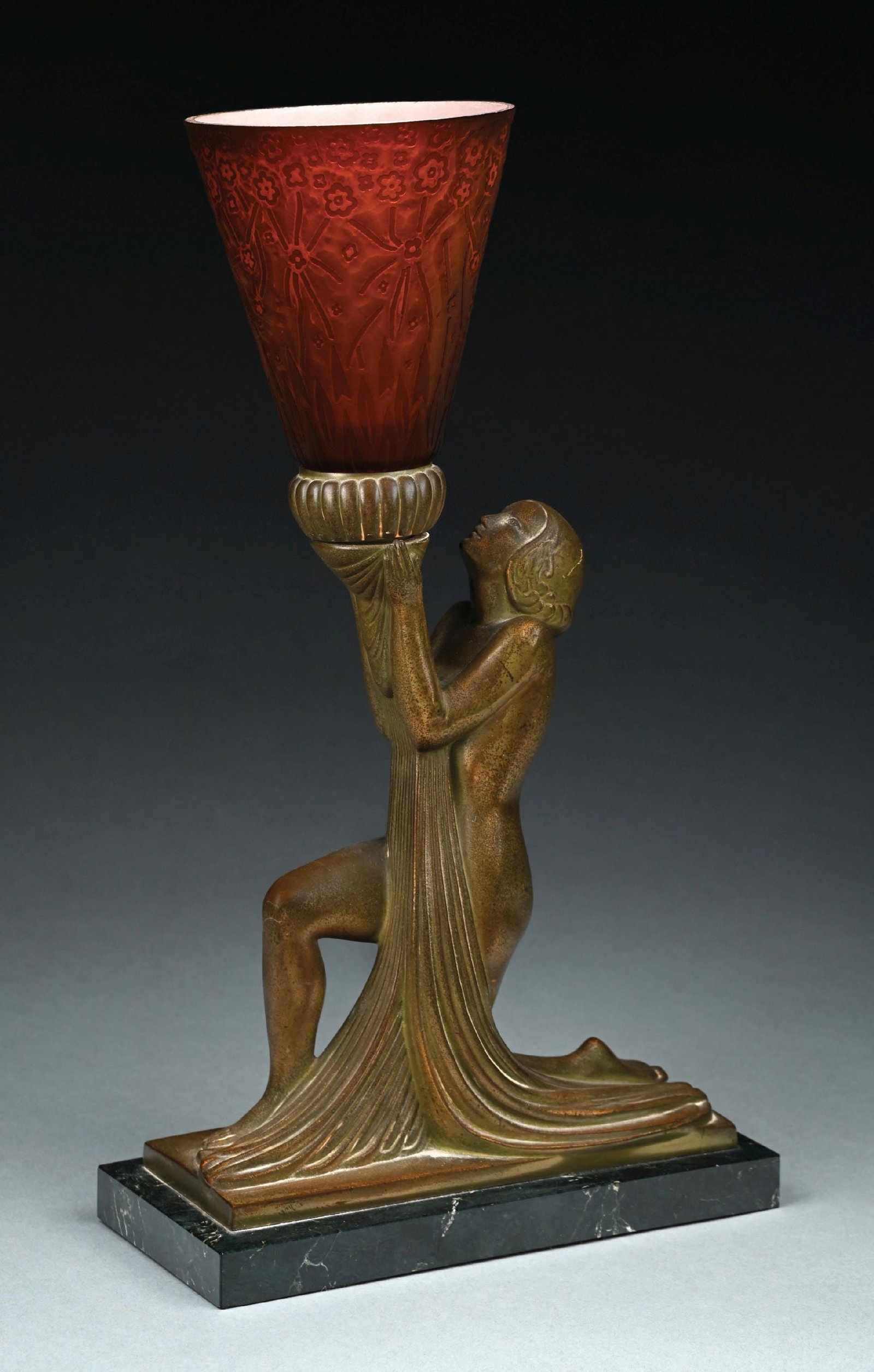 ART DECO FIGURAL METAL AND ECTHED GLASS LAMP ON MARBLE BASE: Woman kneeling on a marble base holding up an orange and red glass etched conical shade decorated with stylized flowers. Condition: (Near Mint). Dimensions: 10 - 1/4" x 4 - 3/4" x 18".