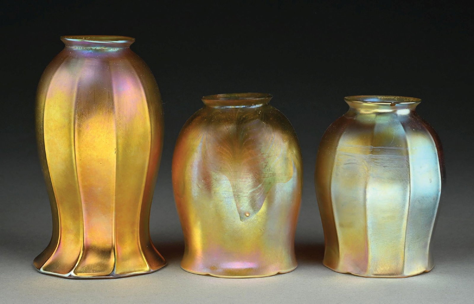 COLLECTION OF 3: TIFFANY STUDIOS FAVRILE GLASS SHADES: A wonderful collection of 3 favrile glass shades by Tiffany Studios. (A) A large tulip shade standing 7" tall, with ribbed form and flared mouth. Signed to the fitter "LCT Favrile". Free of cracks. (B