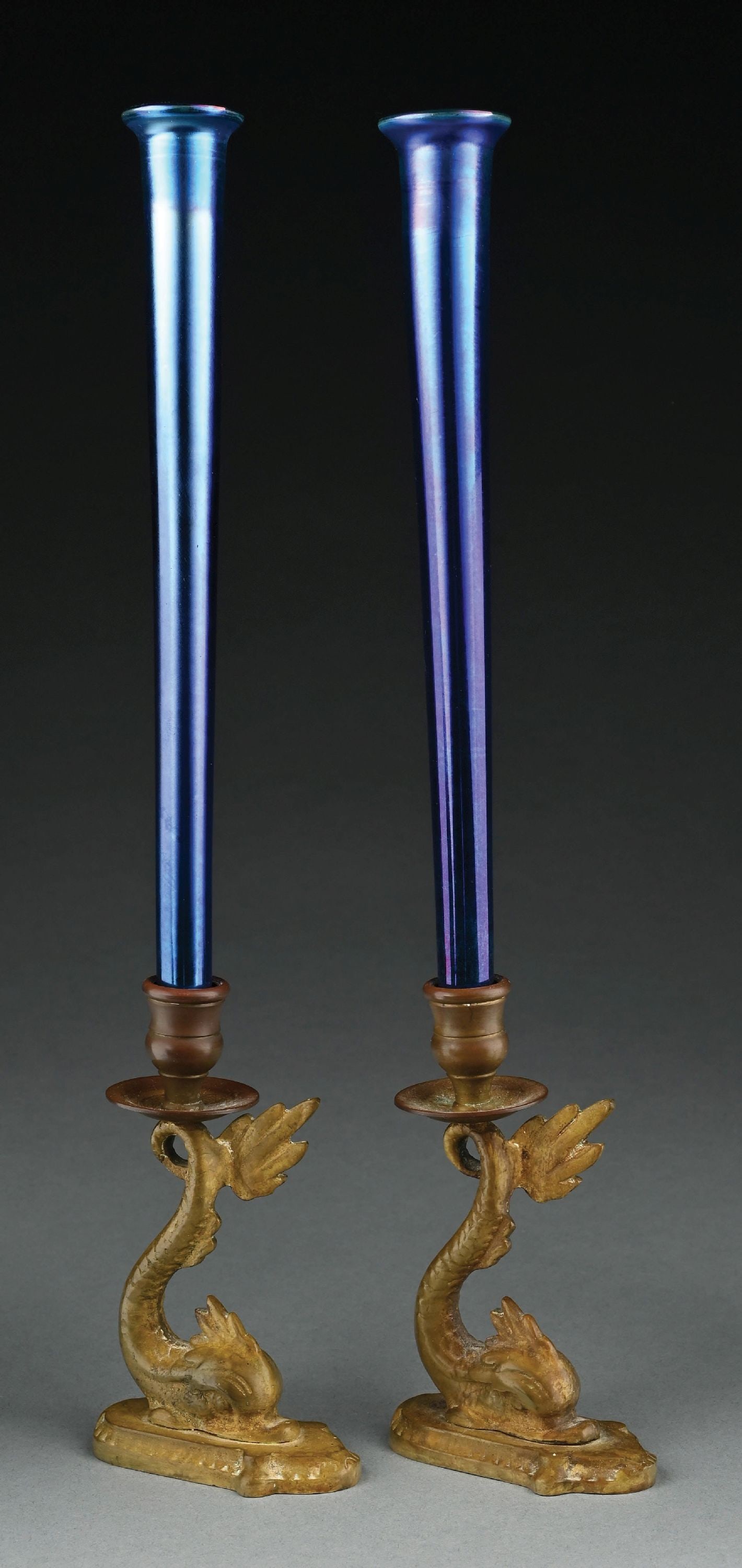 PAIR OF BLUE TIFFANY STUDIOS FAVRILE GLASS CANDLESTICKS W/ 2 BRONZE SEA DRAGON CANDLE HOLDERS: A beautiful set of Tiffany Studios favrile glass candlesticks and two bronze candle holders. Each candlestick measures 11-3/4" tall, and is composed of beautifully iridescent blue favrile glass. Both 