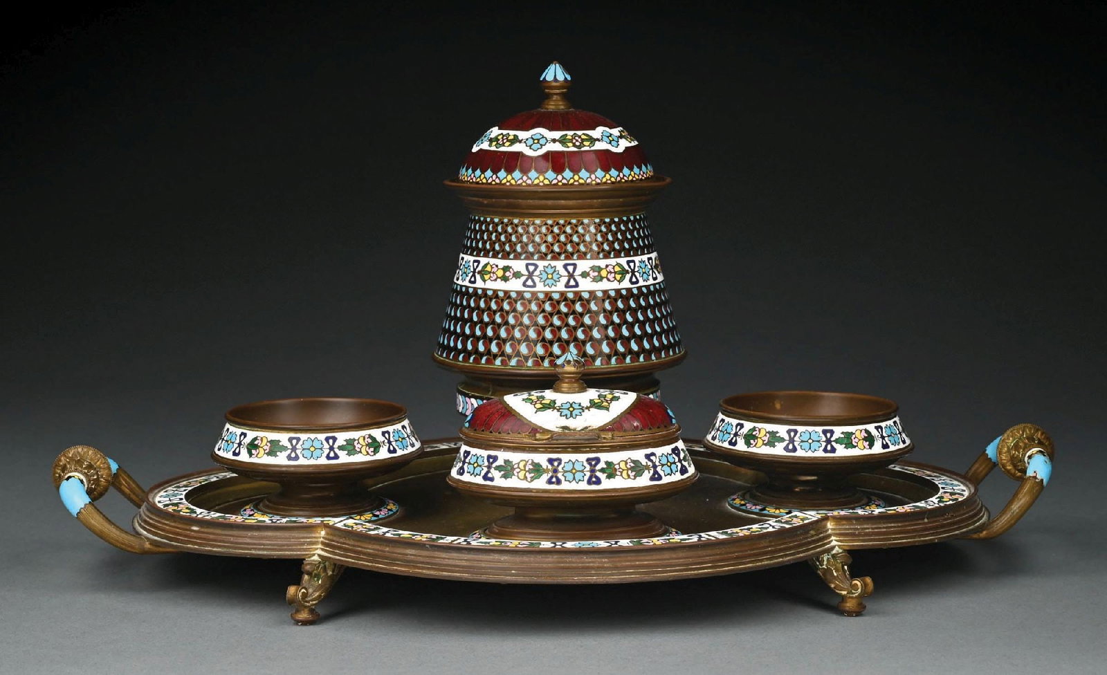 SET OF 5: TIFFANY STUDIOS BRONZE AND ENAMEL SMOKING SET: Includes multi-part enameled smoking set with circular compartments and decorative enameled rims. A lidded bronze and enameled container with geometric and floral decoration. Condition: (Excellent). D