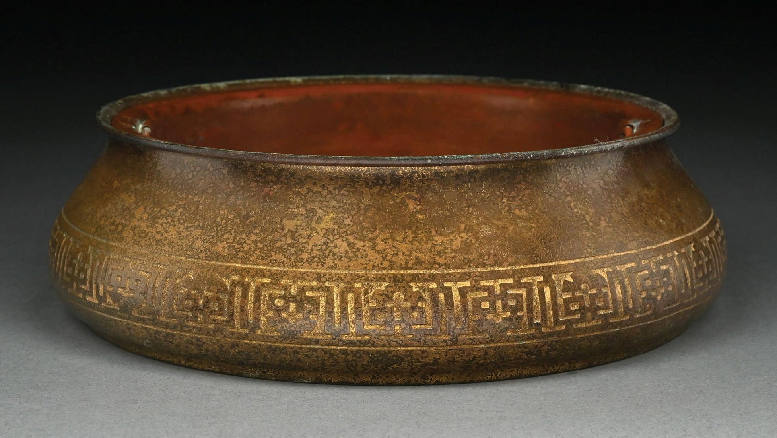 TIFFANY STUDIOS BRONZE PLANTER: A beautiful bronze planter by Tiffany Studios. The 8-1/2" diameter planter is finished in an acid-etched gold dore. Includes original copper insert. The underside is stamped "Tiffany Studios New York
