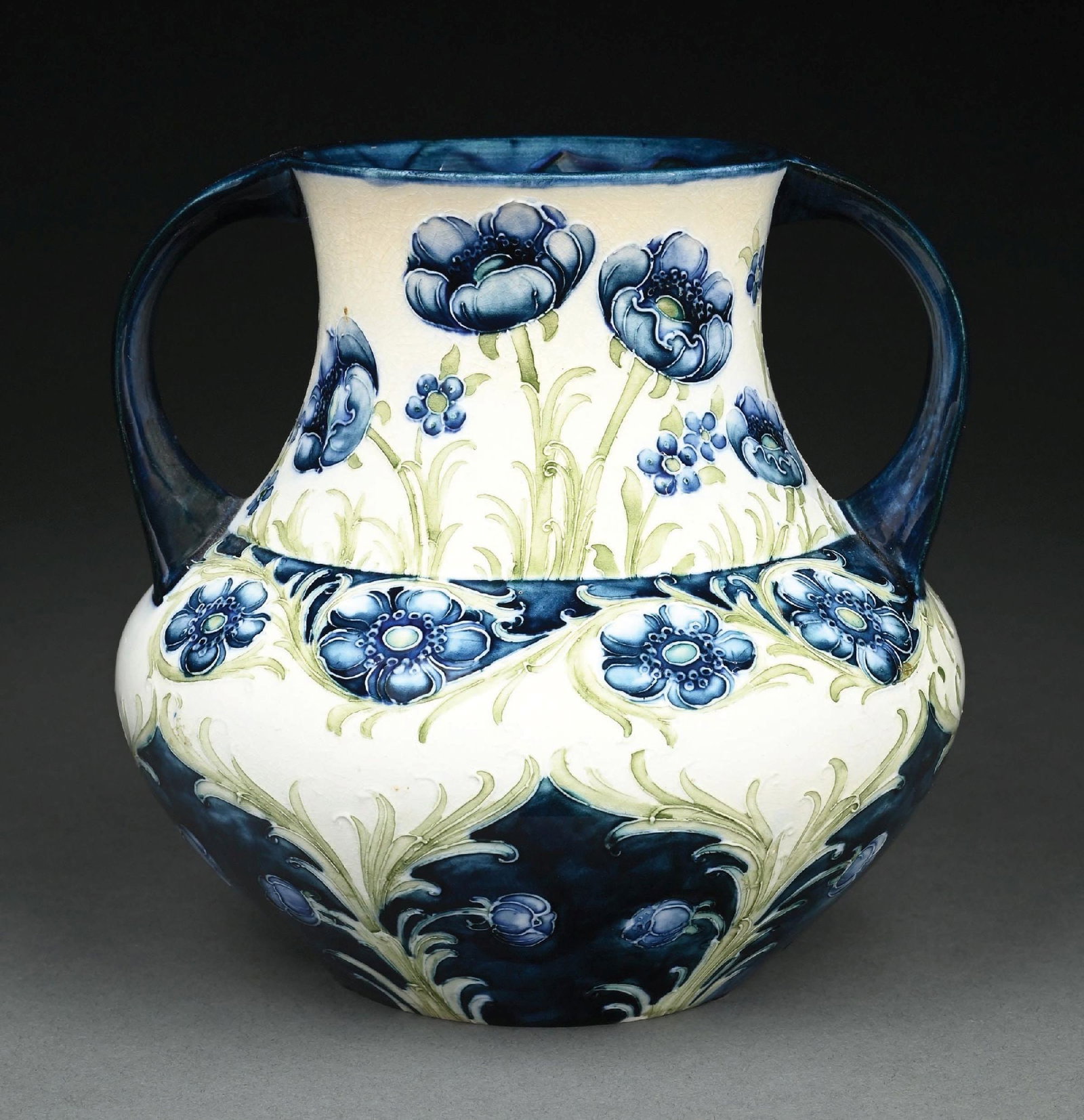 MOORCROFT MACINTYRE FLORIAN WARE POPPY VASE: A beautiful Moorcroft florian ware poppy vase, c. 1904. The 7-1/2" tall round bottom vase has two-handled form, with cream colored background and beautiful blue poppies and forget-me-nots in the