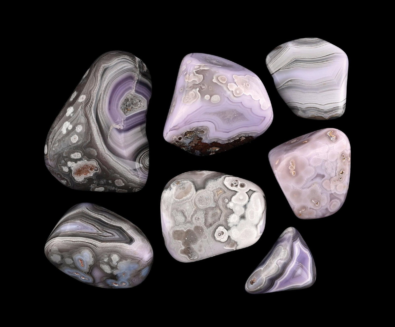 LARGE COLLECTION OF BOTSWANA AGATES: A collection of seven polished agate specimens including Botswana, lace, orbicular, and fortification agates. The group displays strong pattern contrast with lavender, gray, and blue coloration, along