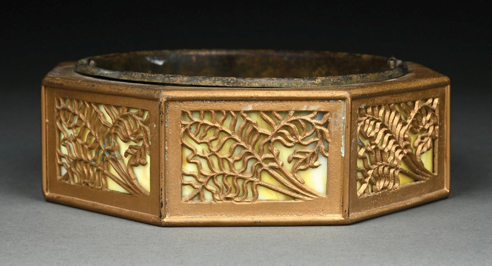 BRASS AND EIGHT-PIECE SLAG GLASS FERN DESIGN PLANTERN: C. 1910–1930. A brass octagonal jardinière featuring eight panels of green slag glass with raised Art Nouveau fern decoration. The planter retains its original removable metal liner with dr