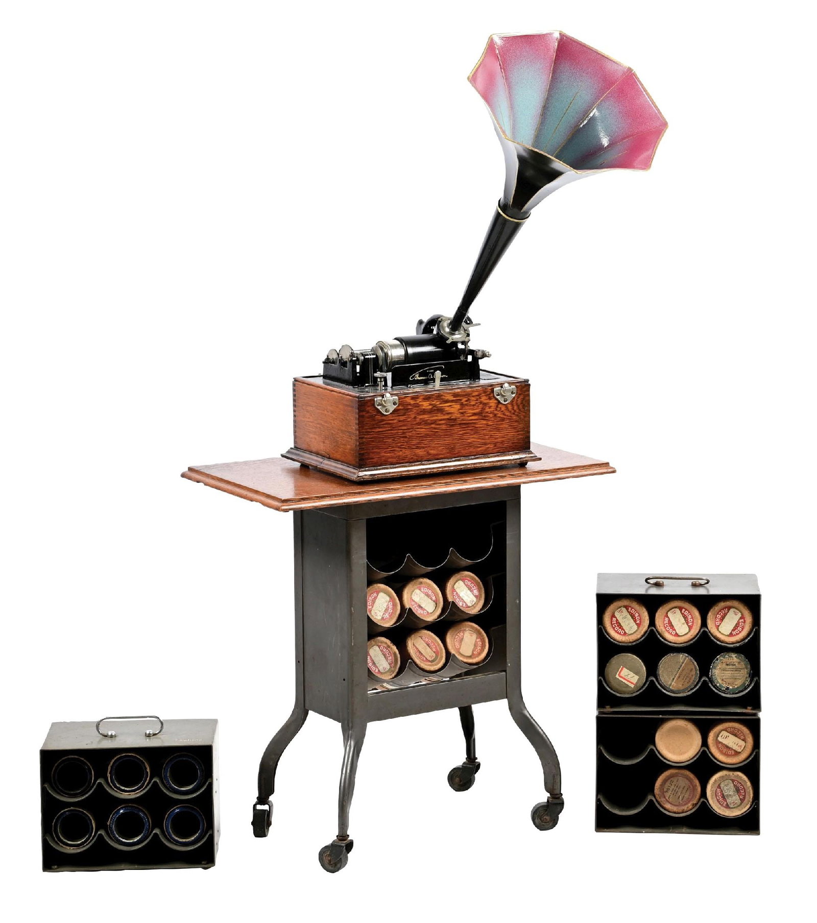 EDISON CYLINDER PHONOGRAPH ON STAND W/ ADDITIONAL CYLINDER CASES: C. 1900. Original finish to the oak case with original paint to the motor housing, with 85% of the original pinstriping. Correct reproducer, correct crank, no lid to the box, and a replaced old small