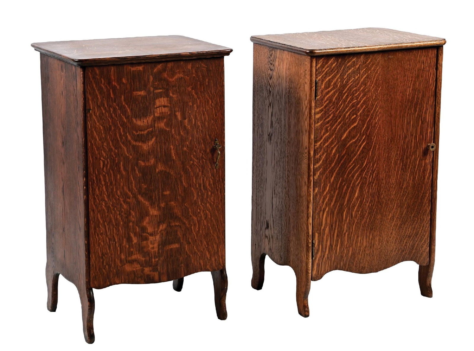 PAIR OF OAK PHONOGRAPH STANDS: (A) An oak phonograph stand with front door and interior record storage. It shows scuffs and scrapes to the lid, and light wear over the rest of the cabinet. (Good). (B) A front door cylinder phonogra