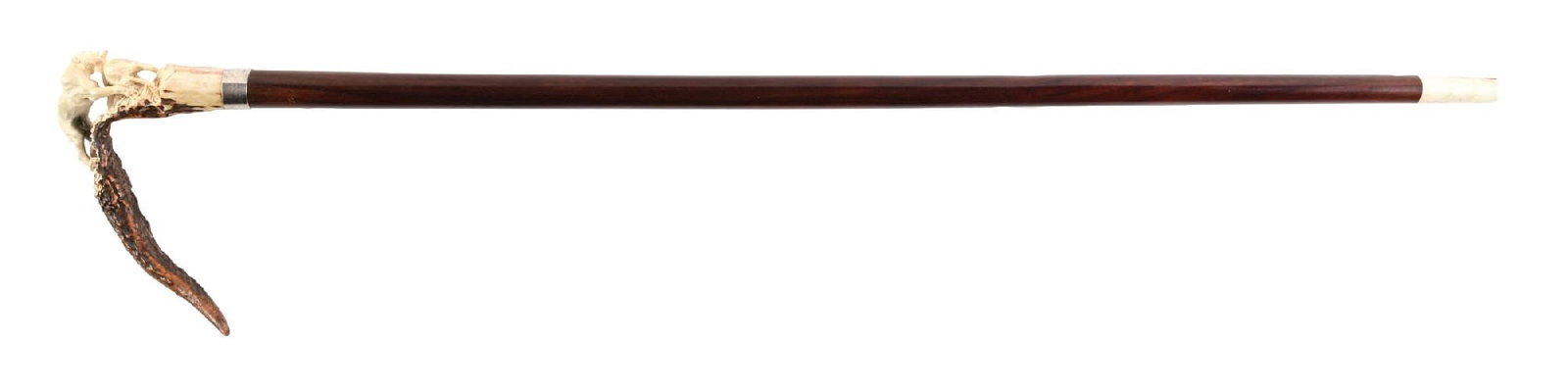 ANTIQUE WALKING STICK W/ CARVED ANTLER STAG HANDLE WITH HUNTING SCENE: C. 1890–1920. Carved stag antler hunting cane featuring a tiger attacking a doe carved in high relief and mounted to a natural antler crook handle with sterling silver collar and hardwood shaft.