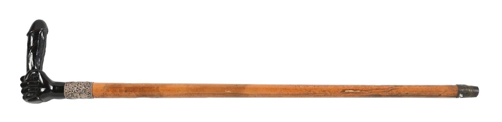 EROTIC PHALLIC BRITISH CANE: A jarring and unusual erotic handled cane featuring a carved black handle in the form of a phallus, mounted above a massive ornate silver collar. The cane is fitted with a thick malacca shaft and a