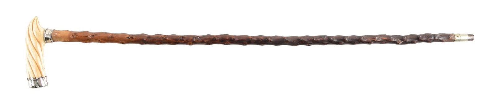 ANTIQUE WALKING CANE WITH TWISTED IVORY HANDLE W/ STERLING SILVER COLLAR AND TRIM: C. 1880–1910. Walking cane featuring a carved ivory spiral twist handle mounted to a sterling silver collar marked “T.D. & V. Sterling,” and fitted to a naturalistic branch wood
