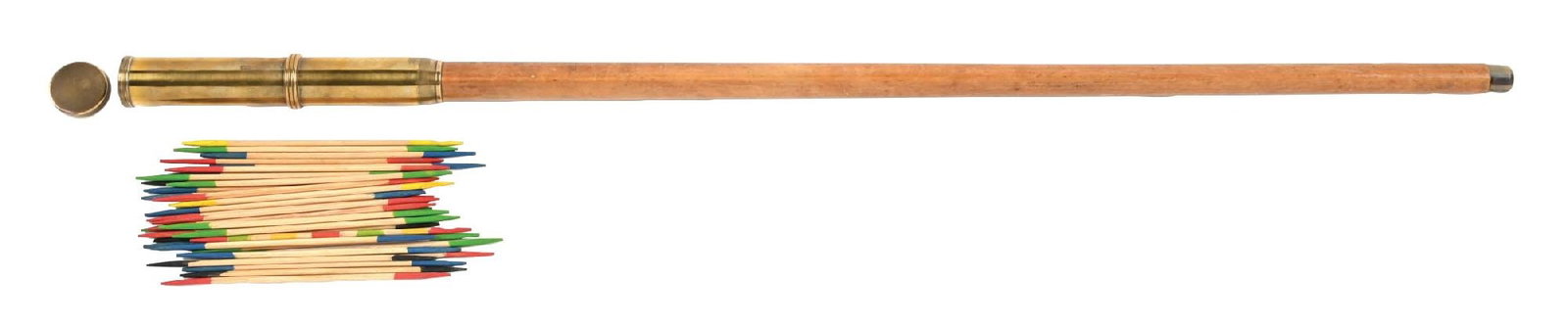 1935 GAME SYSTEM STICK CANE: C. 1935. A fantastic long honey-colored wooden cane featuring an elongated brass handle. When unscrewed, the handle reveals a concealed set of “pick-up sticks” beneath the screw top. The
