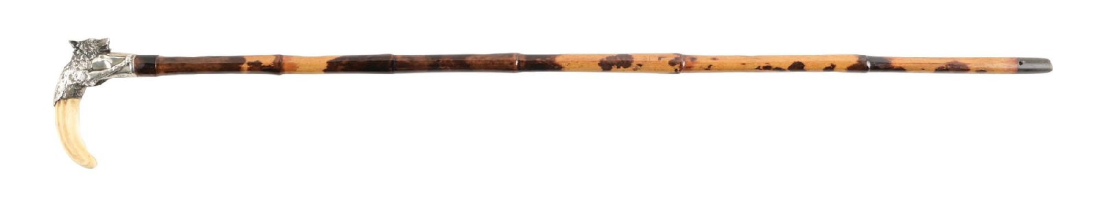 ANTIQUE WALKING CANE W/ IVORY AND STERLING SILVER WOLF HANDLE AND TWO-TONE SHAFT: C. 1895–1910. Figural walking cane featuring a sterling silver wolf head handle with detailed fur and naturalistic modeling, mounted to a curved horn grip and fitted to a Malacca or hardwood