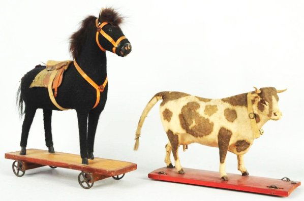 Lot of 2: Early Animal on Platform Toys.: Unmarked but probably German. Includes one cow and one horse; both on wooden platforms with iron wheels. Horse has some damage to horse hair tail and cow has some wear to front mouth area and one slig
