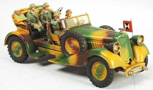 Lineol Camouflage Tinplate Staff Car.: Clockwork motor operates. Electric headlights are not tested. Clean battery box. Cracks in front seat. Crew made up of old figures. Condition (Good - Very Good). Size 9 - 1/2" L.