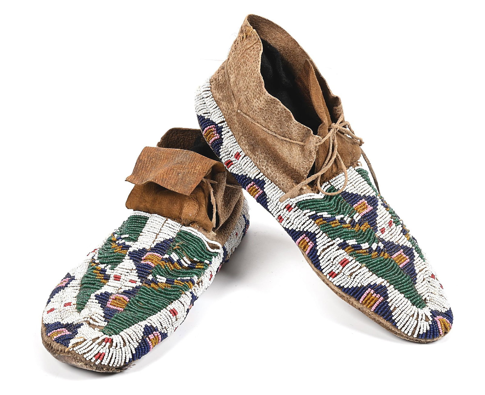SIOUX (LAKOTA) MOCCASINS: With buffalo track pattern and triangular patterns around the edge. Parfleche sole. Sinew sewn. Colors: white, transparent green, transparent yellow, blue, pink, white-heart red Dimensions: 10 - 1/2"