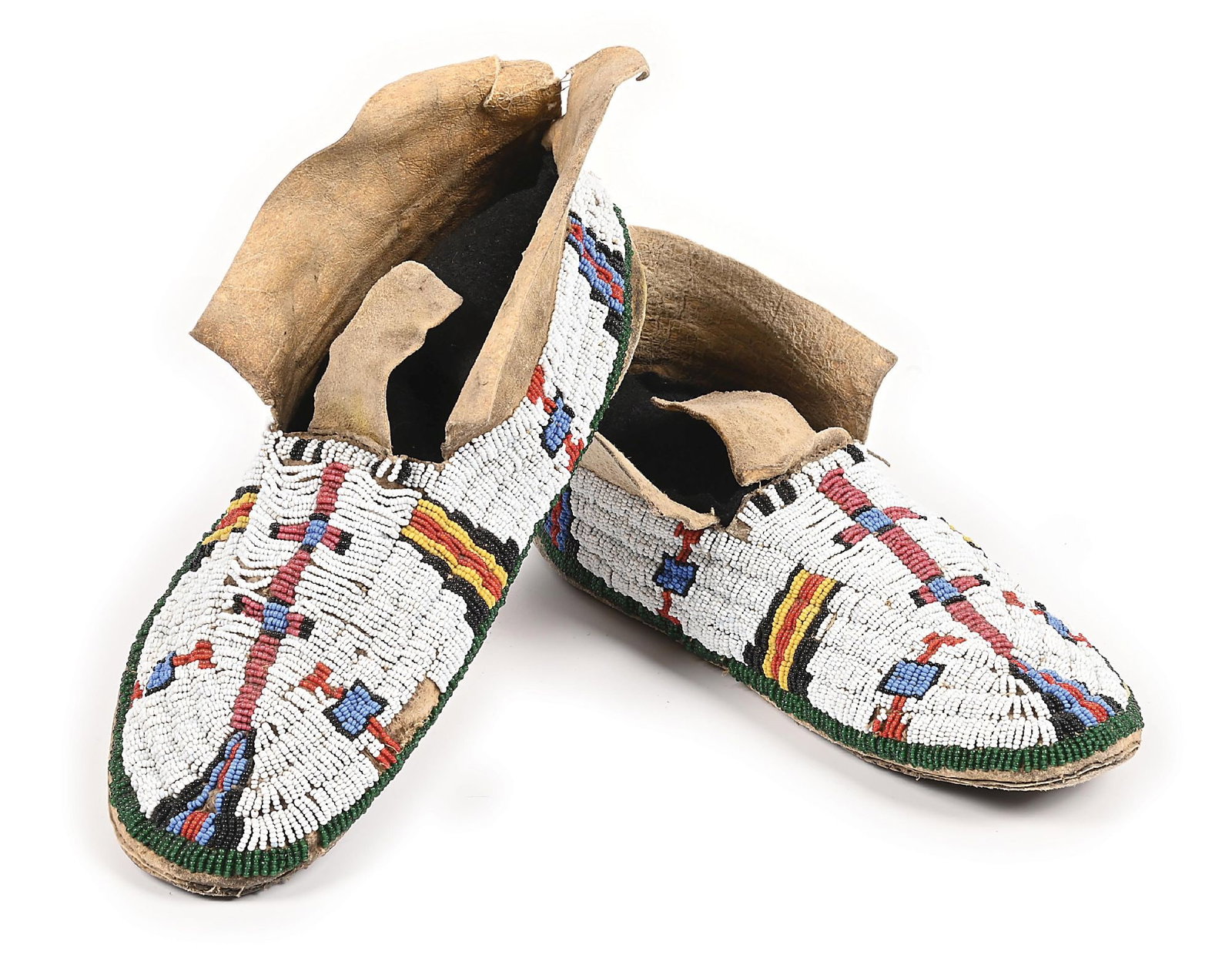 CHEYENNE BEADED MOCCASINS: With a central double cross pattern leading into a stepped diamond, which continues all the way around. Well-worn parfleche sole. Some strands of beads missing on the back side. Colors: white,