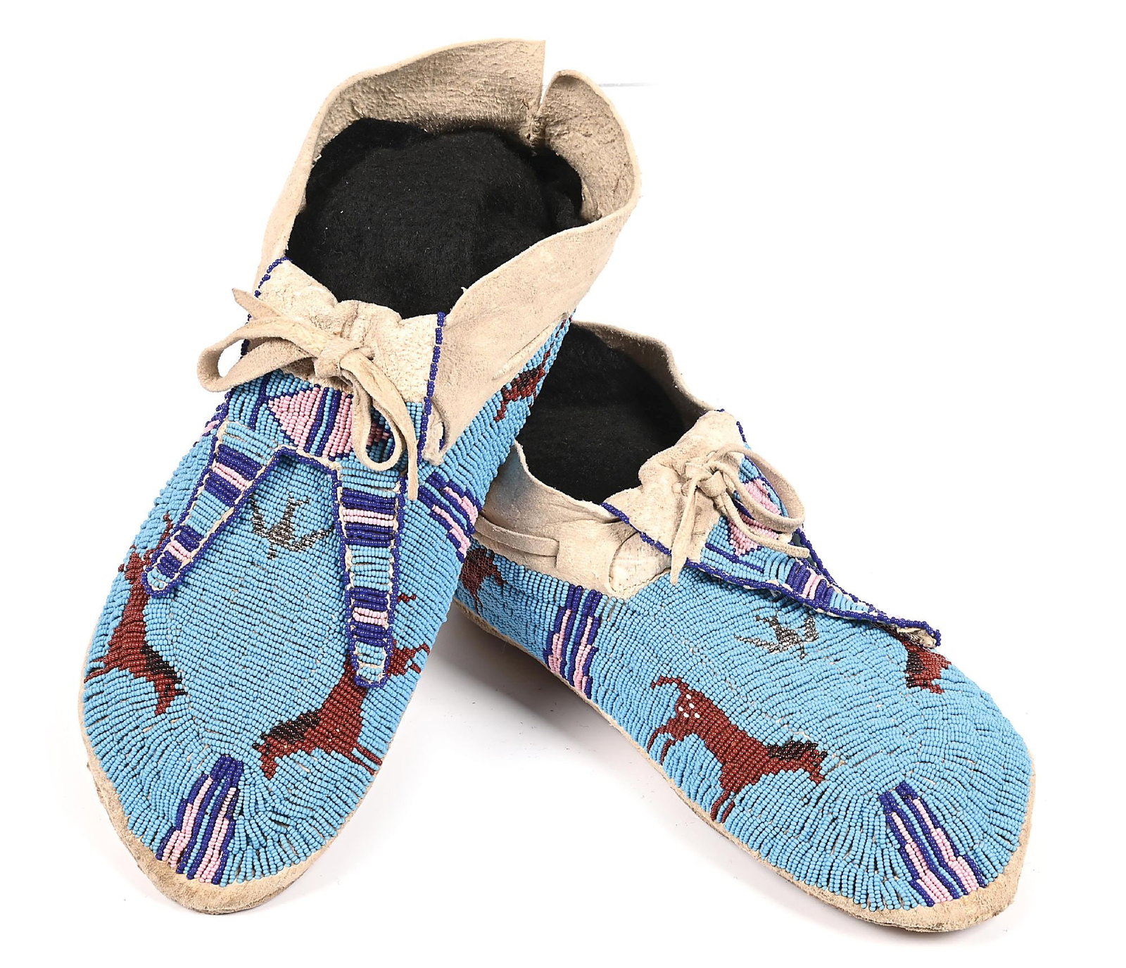 CHEYENNE BEADED MOCCASINS: With horse designs around edge and peyote thunderbird in the top center, all surrounded by geometric patterns. Colors: light blue, brown, dark blue, black, pink, silver Dimensions: 10" L.