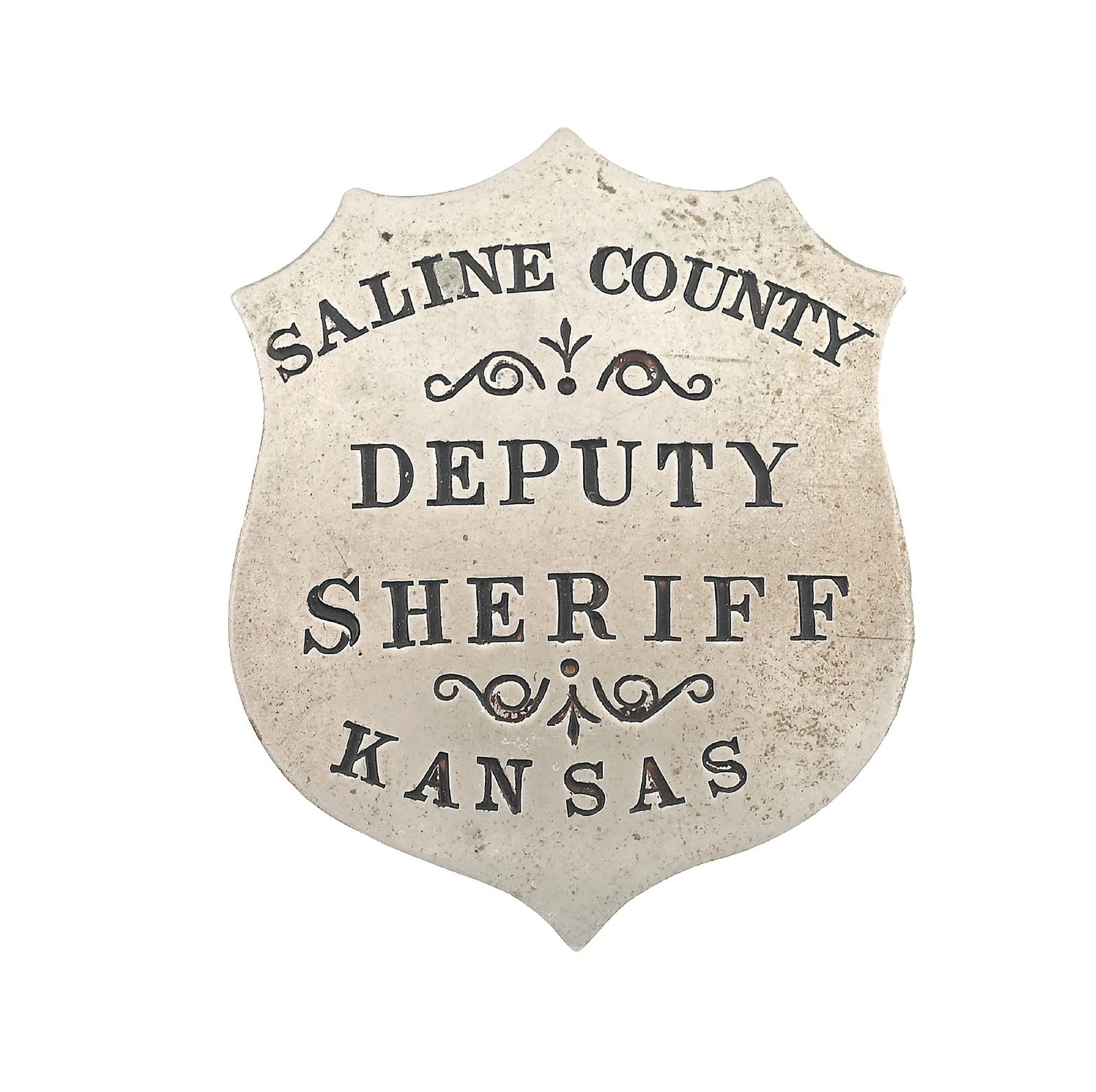 SALINE COUNTY DEPUTY SHERIFF BADGE: Circa 1880s jeweler made SALINE COUNTY / DEPUTY SHERIFF / KANSAS German silver shield with finely recessed soft black lettering. Measures 1-3/4" x 1-1/4". Dimensions: 1 - 1/2" x 1 - 1/2".