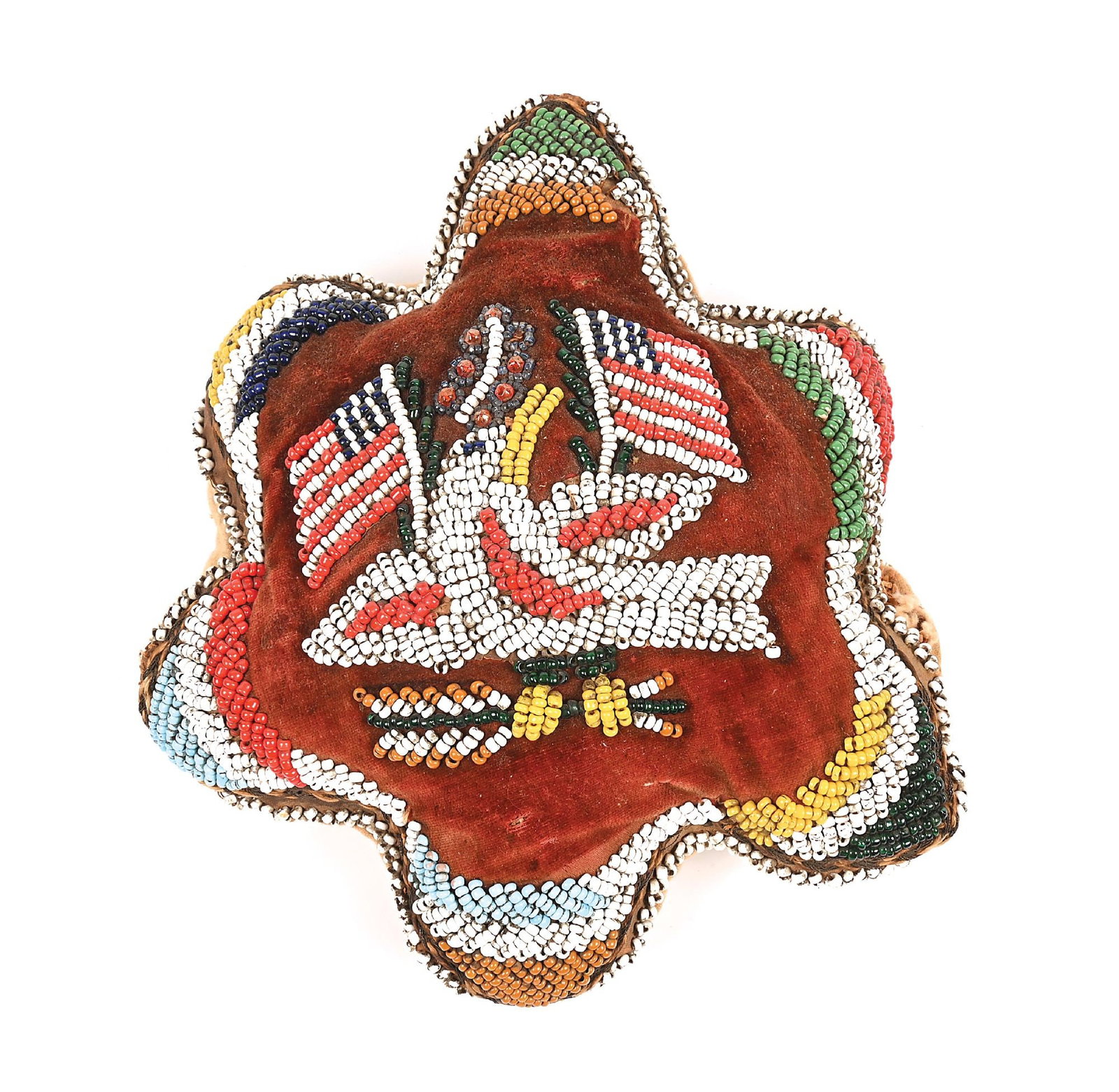 IROQUOIS BEADED CUSHION: Turn of the 19th century. With a central eagle flanked by an American flag on each side. Colors: white, red, blue, green, yellow, light blue Condition: Some beads missing. Small holes in fabric.