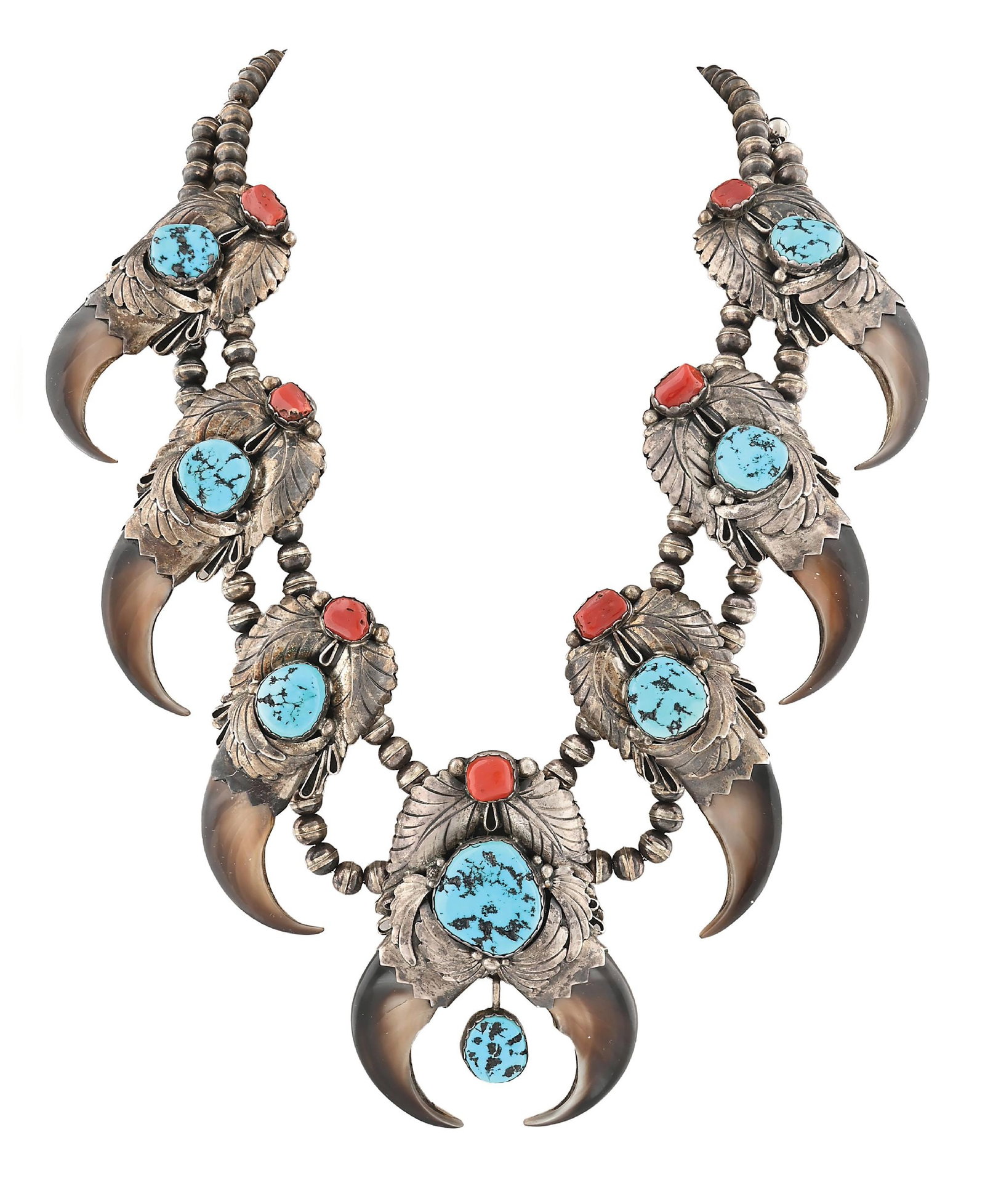 NAVAJO (DINÉ) SQUASH BLOSSOM NECKLACE: With each squash formed from a turquoise and coral cabochon mounted on silverwork in the form of leaves, encasing a bear claw in each. The naja reflective of each squash, but containing two bear claws