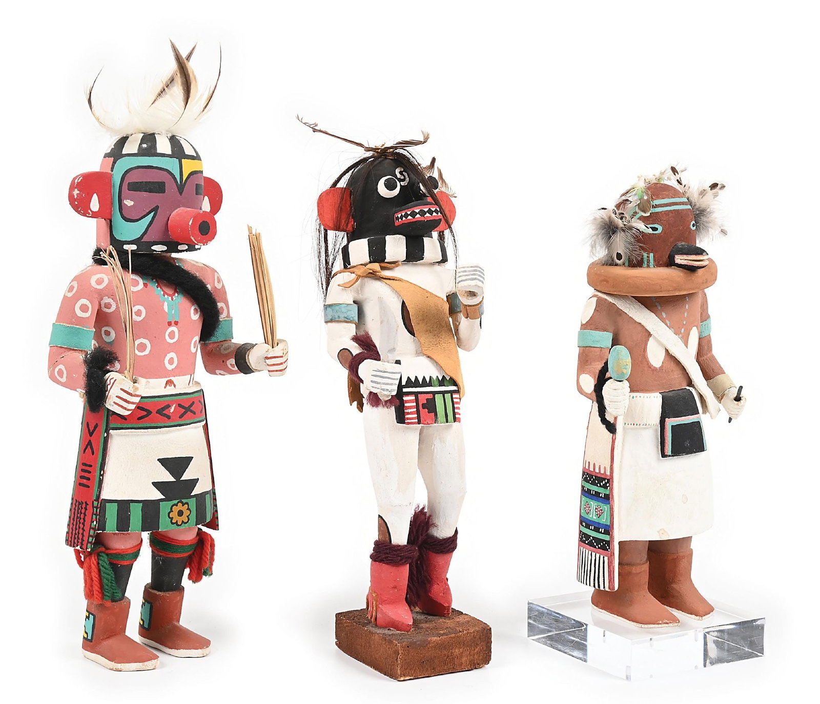 LOT OF 3: HOPI KACHINAS (KATSINAS) CARVINGS: Circa mid-20th century. (A) Holding reeds in each hand, adorned with yarn, feathers, and leather. 5" W x 14" H. Colors: white, flesh, purple, turquoise, black, yellow, green, red (B) Holding a knife
