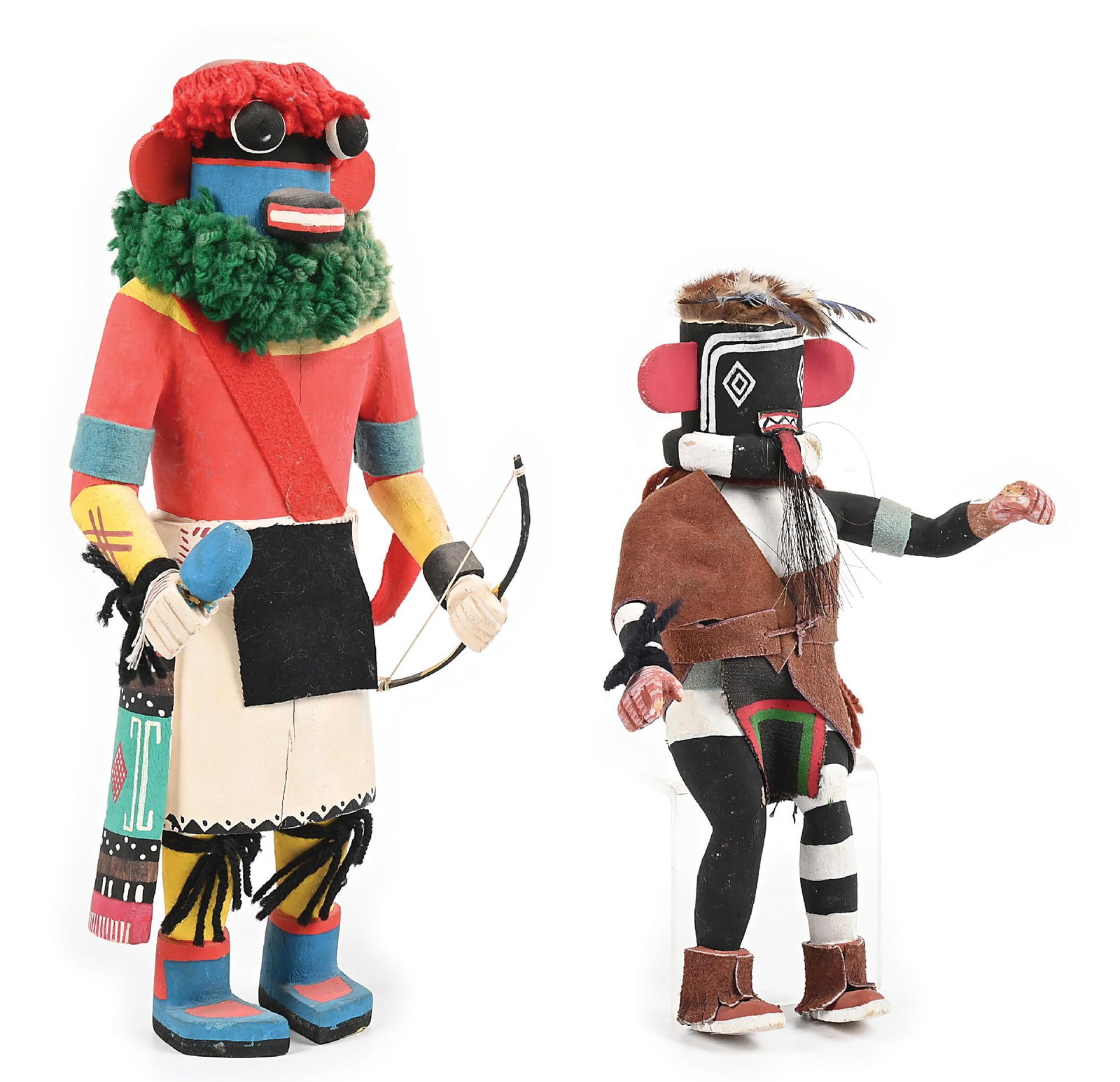 LOT OF 2: HOPI KACHINA (KATSINAS) CARVINGS: Circa 1960s-1970s. (A) Adorned with yarn, feathers, and belt, holding a rattle in one hand and a bow in the other. Dimensions: 6-1/2" W x 15" H Colors: white, red, yellow, black, turquoise, indigo, or