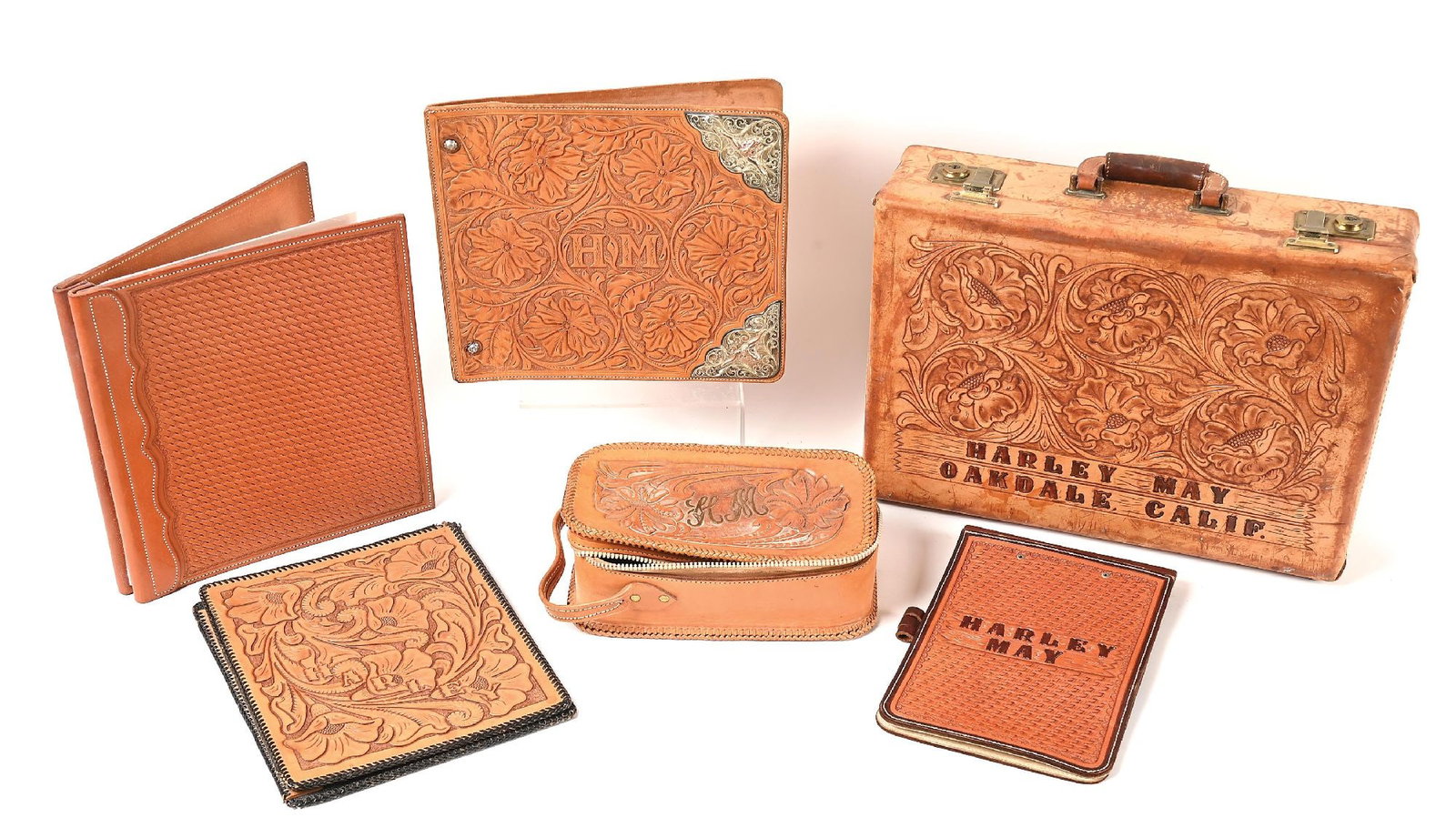LOT OF 6: HARLEY MAY TOOLED LEATHER TRAVELING BRIEFCASE, ALBUMS AND SHAVING KIT BAG: Personal, high quality hand carved leather items used by world champion Harley May. One folder has engraved sterling silver corner accents. Provenance Ex. Harley May Dimensions: Case: 18 - 1/4" x 4 -