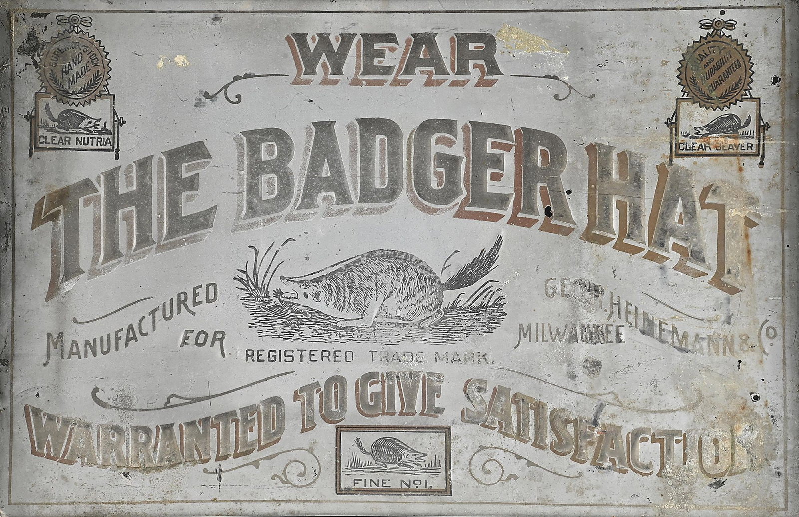 THE G. H. HEINEMANN CO. BADGER HAT FRAMED ADVERTISING SIGN: This slogan was registered in August 1903 by G.H. Heinemann & Co. of Milwaukee., maker of top quality Nutria hats at the turn of the century. This sign measures 19 x 12" and is nicely framed. CONDITIO